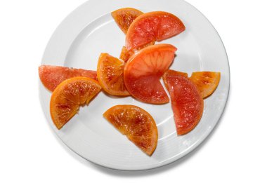 meyve portakalı dilimleri elektrikli süpürge ile pişirilmiş, beyaz arka planda izole edilmiş beyaz tabakta, üst manzara