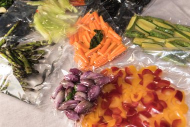 Biber, kabak, arpacık soğanı, taze havuç ve kuşkonmazla pişirilmiş yemek pişirmek için vakumlu poşetler.