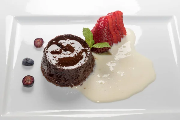 Bunet pudingi, geleneksel İtalyan Piedmont tatlısı beyaz tabakta çilek ve eggnog.