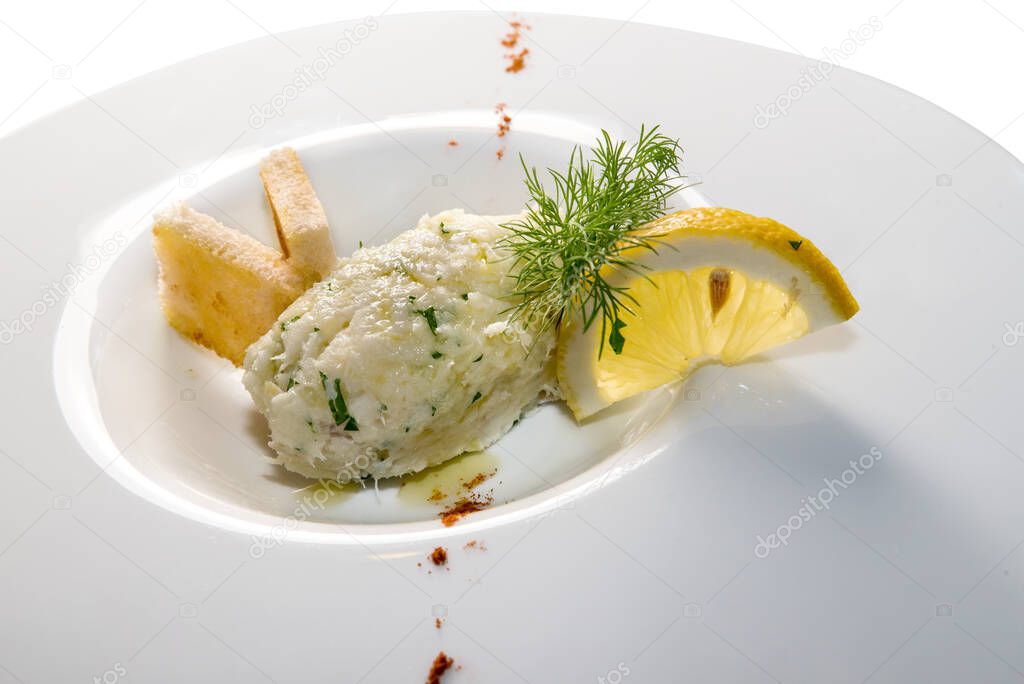 creamy cod, typical Venetian appetizer, called baccal mantecato in a white dish with lemon slice and toasted bread