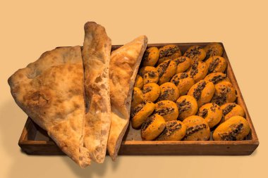 Focaccia ekmeği ve zeytinli taze çörekler ahşap tepside, bej arka planda izole edilmiş.