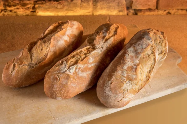 Duże Rustykalne Bochenki Świeżo Upieczonego Chleba Zakwaśnego Drewnianej Desce Krojenia — Zdjęcie stockowe