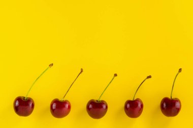 Kırmızı kirazlar, arka plandaki sarı çerçevenin altında fotokopi alanı var. Etiket, tebrik kartı, poster tasarımı.