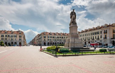 CUNEO, PIEDMONT, ITALY - 9 Haziran 2021: Piazza Tancredi Duccio Galimberti Giuseppe Barbaroux heykeli, Cuneo 'nun ana meydanı ve Corso Nthe arka planda.