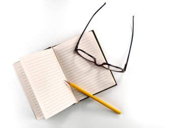 Sarı kalem ve gözlüklü klasik çizgili defter, beyaz arkaplanda izole edilmiş, boşluğu kopyala