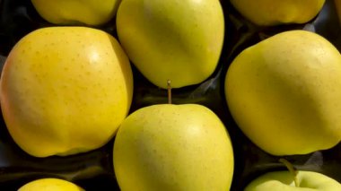 Karton sandıkta sıralanmış altın elmalar, sarı elmalar üzerinde iz sürme çekimi