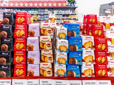 Italy - November 20, 2025: Panettone and pandoro cakes in Balocco, Maina, and Bauli brand packaging displayed in an Italian supermarket for sale for the Christmas holidays.