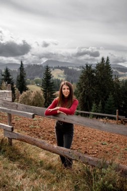 Dağların arkasında tek başına duran güzel bir kızın portresi. Güzel gökyüzü, güzel doğa