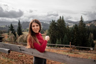 Dağların arkasında tek başına duran güzel bir kızın portresi. Güzel gökyüzü, güzel doğa