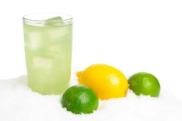 Склянка соку лайма з кубиками льоду, липами, лимоном на снігу на білому — стокове фото