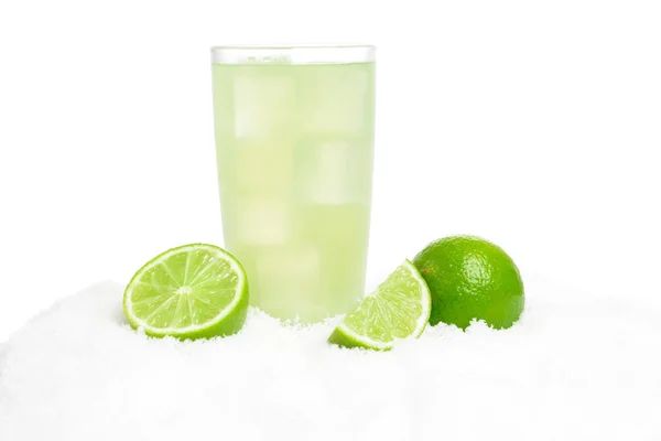 Glass of lime juice with ice cubes,limes on snow on white — Stock Photo, Image