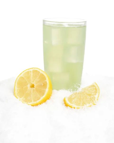 Стакан лаймового сока с кубиками льда, половинки лимонов на снегу на белом — стоковое фото