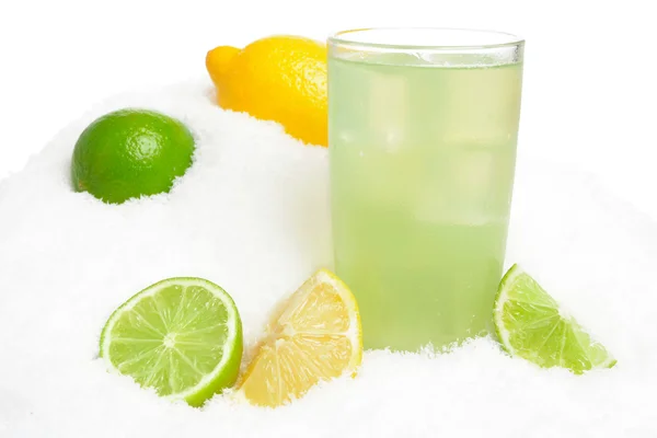 Glass of lime juice with ice cubes,limes and lemons halves on snow on white — Stock Photo, Image