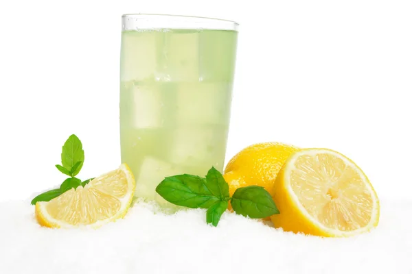 El vaso del jugo de limón, los cubos de hielo sobre la nieve sobre blanco — Foto de Stock