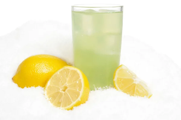 Glass of lime juice with ice cubes,lemons on snow on white — Stock Photo, Image
