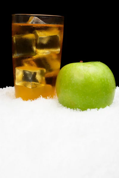 Sumo de maçã, cubos de gelo e maçã preta na neve — Fotografia de Stock