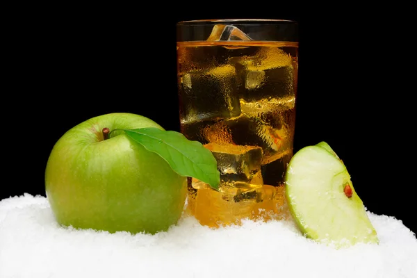 Suco de maçã congelado, cubos de gelo e maçã com folhas pretas na neve — Fotografia de Stock