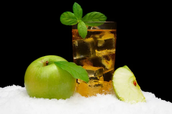 Suco de maçã gelado, cubos de gelo e maçã com folhas no preto na neve — Fotografia de Stock