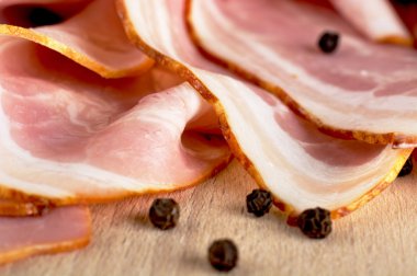 Pembe pastırma ile ahşap tahta üzerinde siyah biber dilimleri