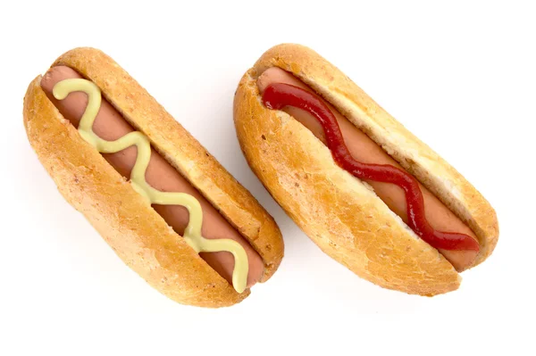 Cachorros-quentes com mostarda e ketchup isolados em branco — Fotografia de Stock
