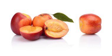 birkaç dilimlenmiş nektarin yaprak üzerinde beyaz izole