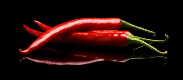 Červené chilli papričky, izolované na černém pozadí — Stock fotografie