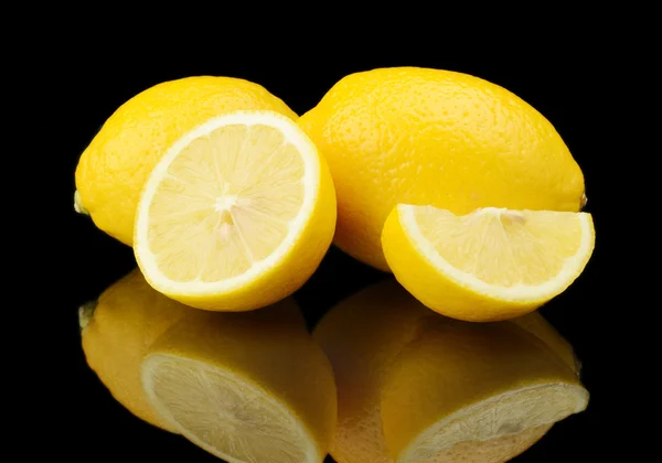 Studio shot rebanó tres limones aislados en negro —  Fotos de Stock