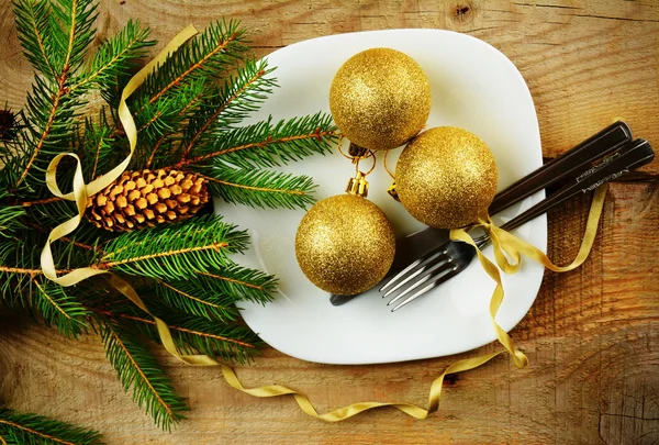 Χριστουγεννιάτικο πιάτο χρυσά στολίδια πεύκα ξύλινη επιφάνεια — Φωτογραφία Αρχείου