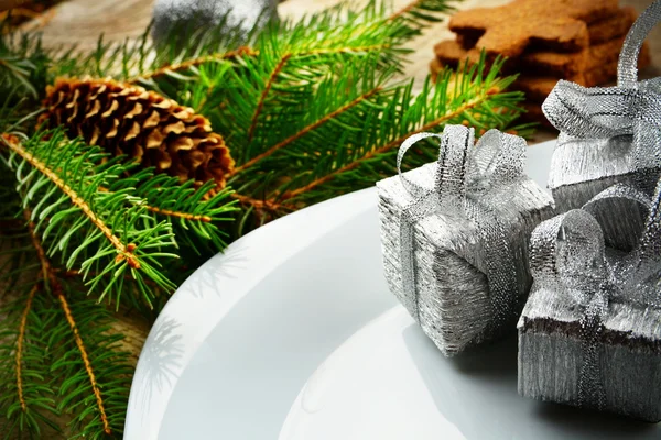 Крупный план Рождественская тарелка серебряные подарки сосны деревянная поверхность — стоковое фото