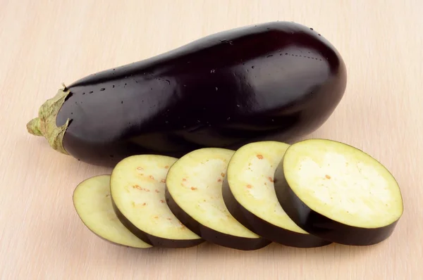 Studio shot single wet aubergine eggplant on wooden table — Stock Photo, Image