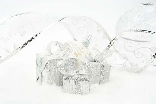 Ασημένια δώρα Χριστουγέννων με ασημένια κορδέλα στο χιόνι — Φωτογραφία Αρχείου