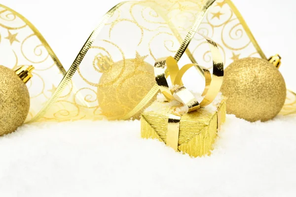 Goldene Weihnachtsgeschenke, Christbaumkugelband auf Schnee — Stockfoto
