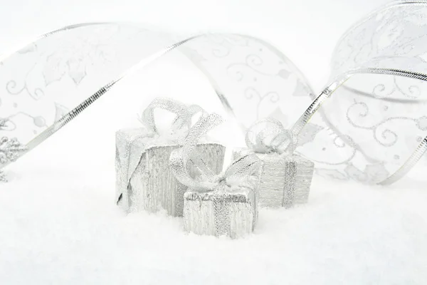 Regalos de Navidad de plata con cinta de plata en la nieve — Foto de Stock