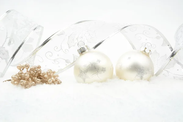 Silver christmas baubles,snowflake with rowan and silver ribbon on snow — Stock Photo, Image