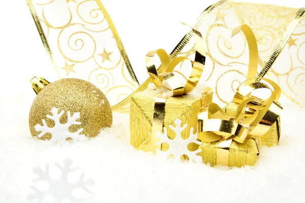 Goldene Christbaumkugeln, Geschenke, Schneeflocken mit goldenem Band auf Schnee — Stockfoto