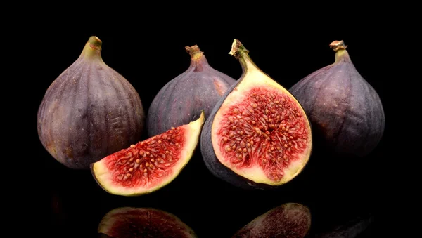 Group sliced figs isolated on black background — Stock Photo, Image