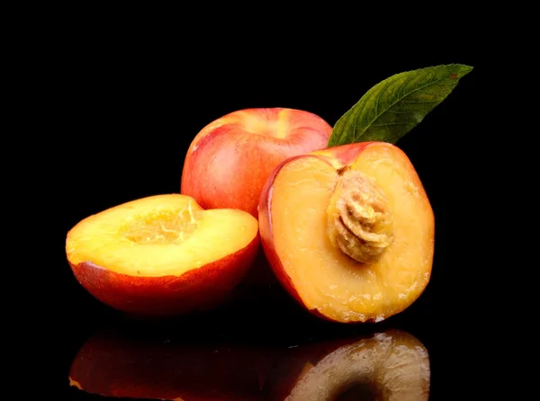 Few sliced nectarines with leaf isolated on black — Stock Photo, Image