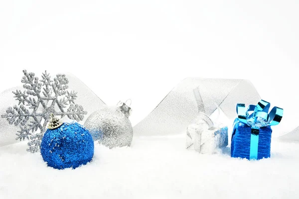 Plata y azul navidad adornos brillantes con cinta en la nieve —  Fotos de Stock