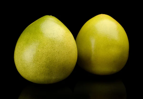 Twee pomelo chinese grapefruits geïsoleerd op zwart — Stockfoto
