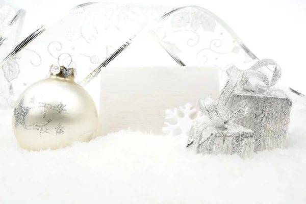 Silver christmas decoration on snow with wishes card — Stock Photo, Image