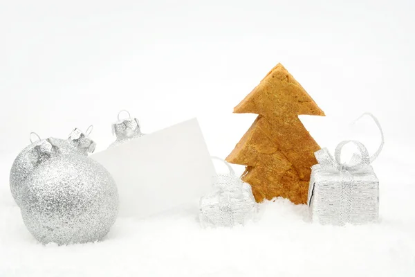 Decoración de Navidad de plata en la nieve con tarjeta de deseos y galletas —  Fotos de Stock