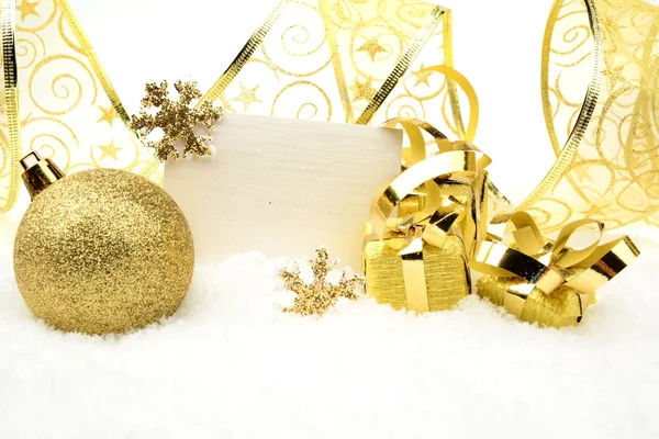 Złota ozdoba Bożego Narodzenia na śniegu z karta życzenia — Zdjęcie stockowe