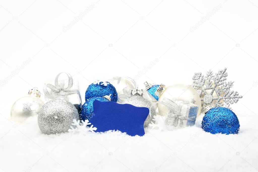 Silver and blue christmas decoration on snow with wishes card