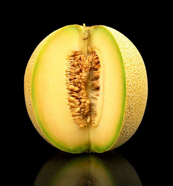 Melon galia notched with seeds isolated black in studio