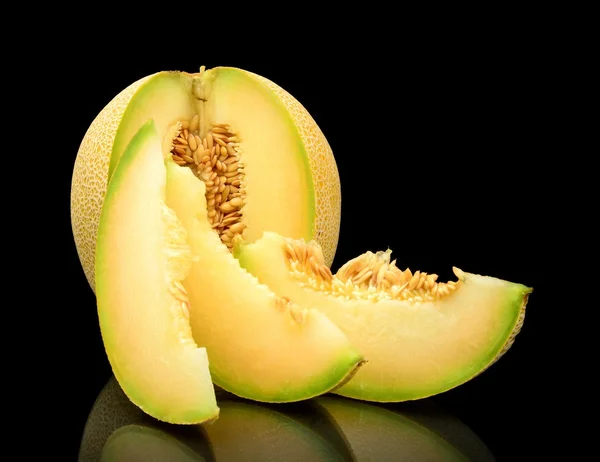 Melon galia notched with slices isolated black in studio — Stock Photo, Image