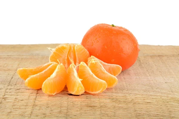 Mandarines with pieces isolated on wooden table — Stock Photo, Image