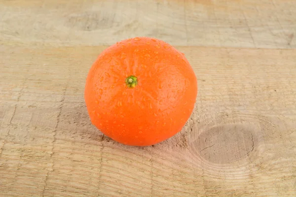 Studio shot wet tangerine isolated on wooden table — Stock Photo, Image