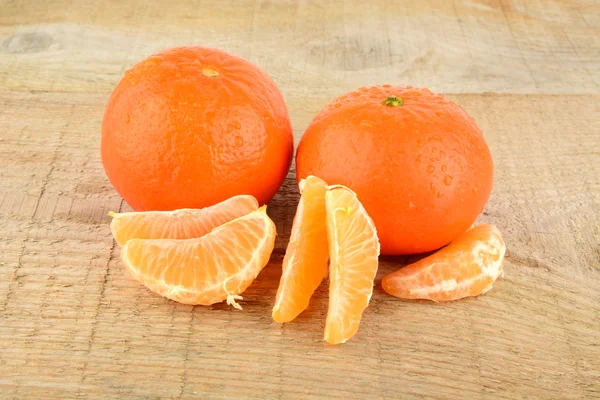 Mandarinas com peças isoladas na mesa de madeira — Fotografia de Stock