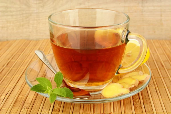 Ginger tea-ingwertee on wooden mat with lemon — Stock Photo, Image