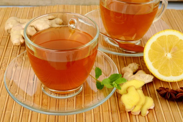 Ginger teas on wooden mat with lemon — Stock Photo, Image